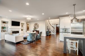 Open concept living room and kitchen with wide plank hardwood flooring in a modern Bardstown Kentucky home