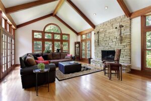 Living room with hardwood floors area rug and stone fireplace in a comfortable Lexington Kentucky home